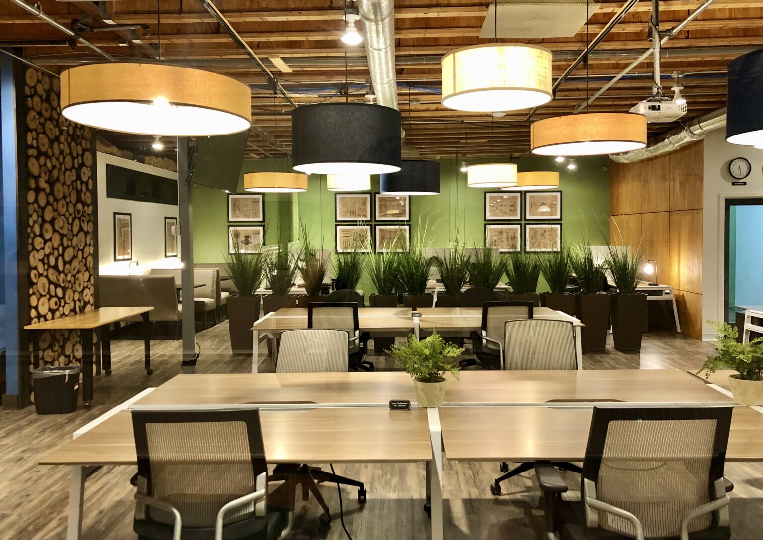 Open coworking area at Olio with pendant lights and plants